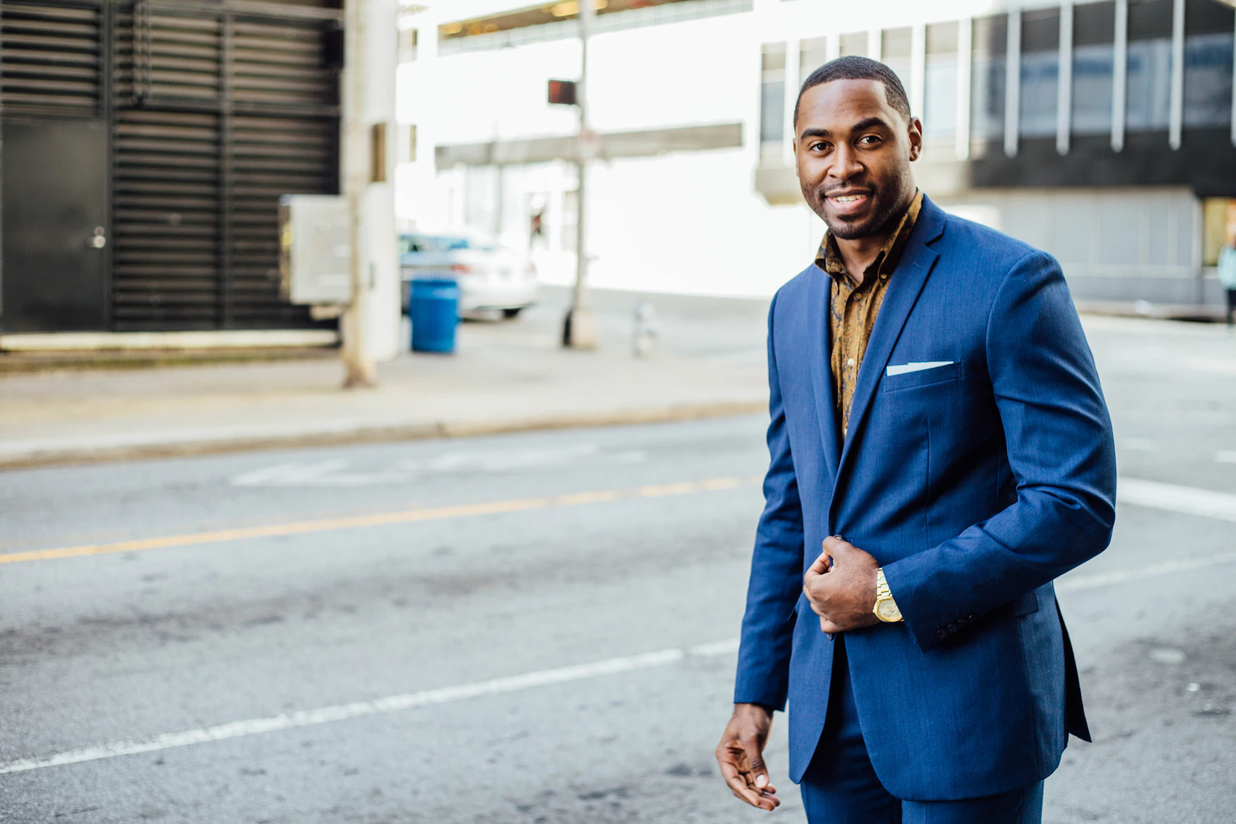 A welcoming professional attorney standing outside in a business suit.